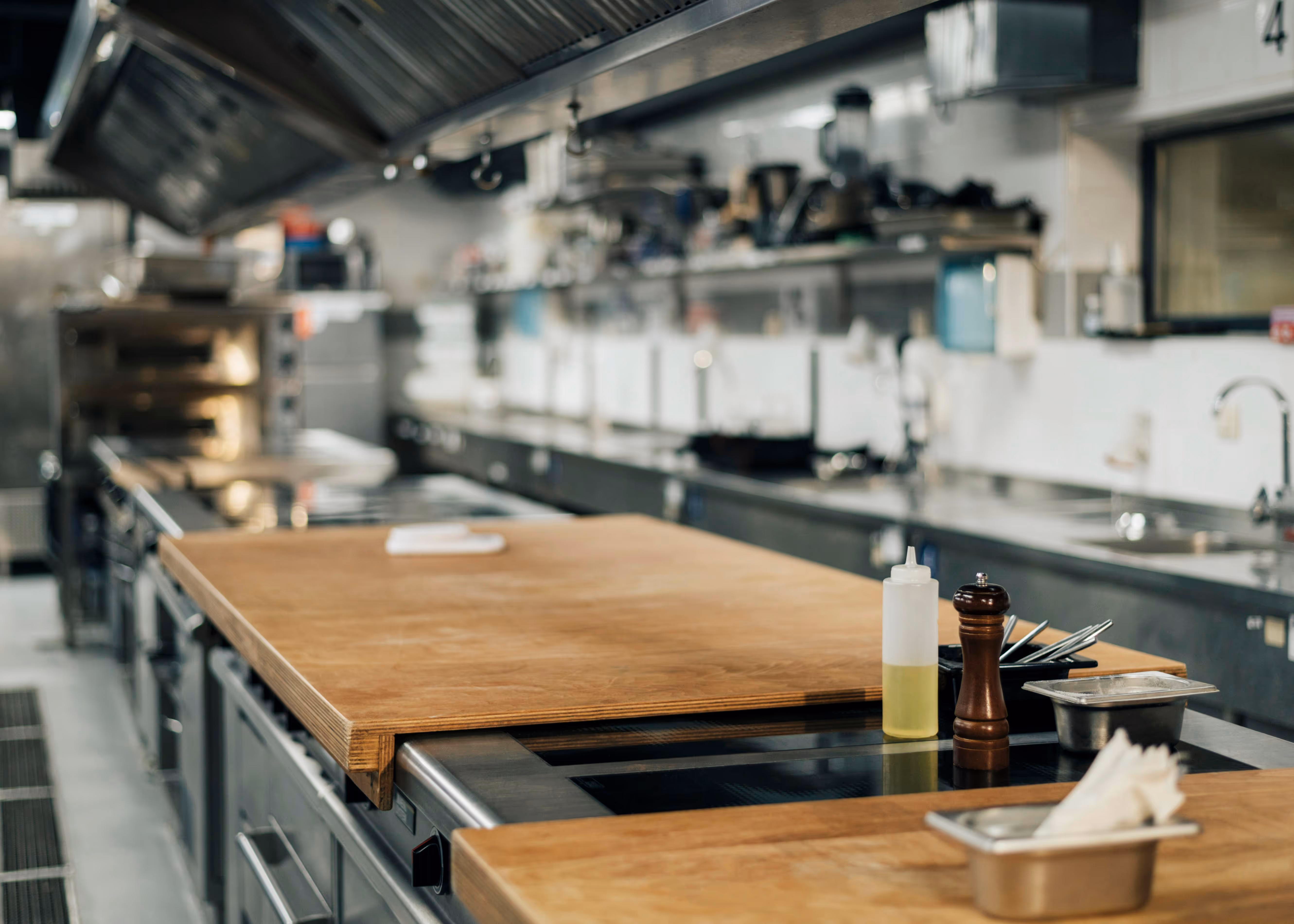 A professional kitchen with clean countertops and cooking equipment neatly arranged.